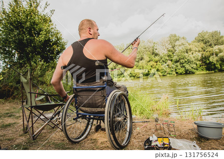 Handicapped man fishing at a lake. Wheelchair camping. Handicapped man fishing at a lake. Wheelchair camping. 131756524