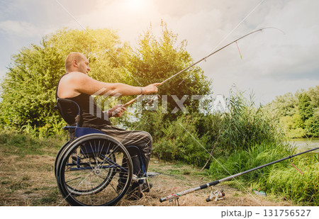 Handicapped man fishing at a lake. Wheelchair camping. 131756527