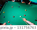 Young man trying to hit the ball in billiard. 131756763