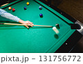 Young man trying to hit the ball in billiard. 131756772