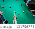 Young man trying to hit the ball in billiard. 131756775