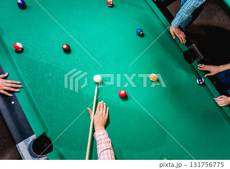 Young man trying to hit the ball in billiard. 131756775