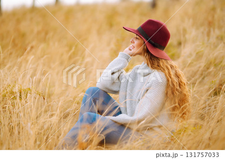 Stylish woman in hat enjoying autumn weather in the park. Fashion, style concept. Stylish woman in hat enjoying autumn weather in the park. Fashion, style concept. 131757033