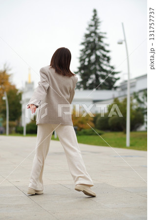 A senior woman twirls in place, smiling brightly as her coat flows. It reflects emotional well-being, freedom from judgment, and the stylish face of active aging. 131757737