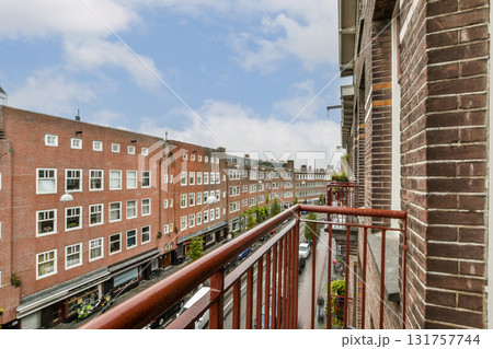 A beautiful urban landscape captured from a balcony, showcasing classic architecture and a lively street, framed by a clear sky and charming facades. 131757744