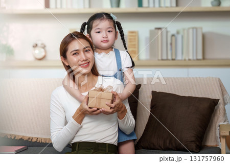 Mother and Daughter Celebrating with a Gift Mother and Daughter Celebrating with a Gift 131757960