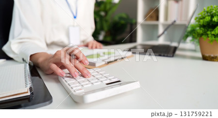 Business professional using calculator for financial analysis in office 131759221