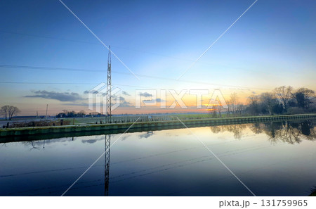 A Beautiful and Tranquil Sunset Reflection Over Calm and Serene Water as the Day Turns into Night 131759965
