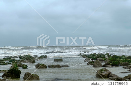 A Vibrant and Stormy Ocean Landscape Featuring a Rugged and Rocky Shoreline Below the Sky A Vibrant and Stormy Ocean Landscape Featuring a Rugged and Rocky Shoreline Below the Sky 131759966