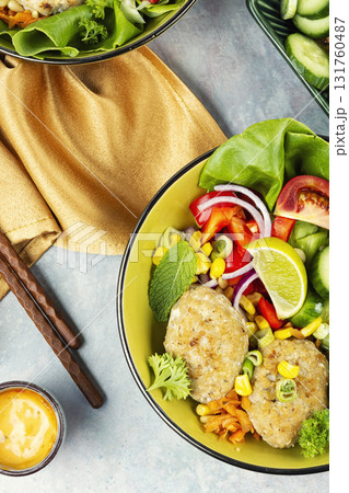 Buddha bowl with vegetables and fish cutlets. 131760487
