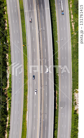 Drone shot aerial view multiple highway lanes in Thailand with few vehicles. Clean asphalt, green roadside, and minimal traffic convey efficiency and motion 131761415