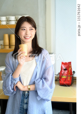 コーヒーを持って微笑む女性 コーヒーを持って微笑む女性 131761642