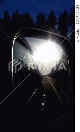 car mirror reflection of the morning sun in the mirror the terrain in the background 131762122