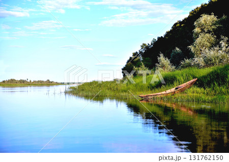 old boat riverside green grass, green trees, blue sky 131762150