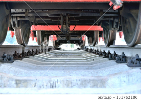 Old railway locomotive, bottom view, standing on rails, 131762180