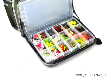 A box with a variety of silicone baits lies in a fishing bag, white background close-up 131762193