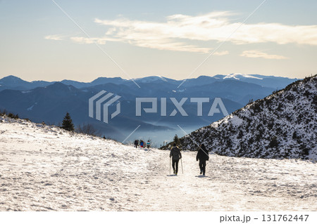 Hikers on snowy mountain trail, scenic view. The Mala Fatra national park in northwest of Slovakia, Europe. Hikers on snowy mountain trail, scenic view. The Mala Fatra national park in northwest of Slovakia, Europe. 131762447