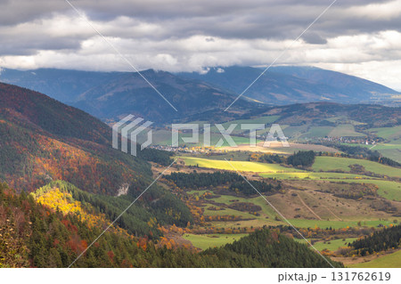 Panoramic view of a valley landscape under a cloudy sky. Mountains are in the distance. The Liptov region in Slovakia, Europe. Panoramic view of a valley landscape under a cloudy sky. Mountains are in the distance. The Liptov region in Slovakia, Europe. 131762619