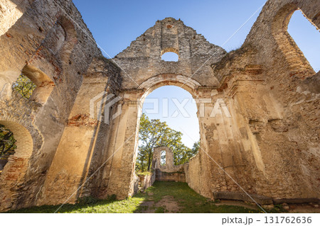 The Katarinka, ruins of a Franciscan monastery and church in Slovakia, Europe. Old church ruins stand against a bright blue sky, stone walls and archway framing the view beyond. The Katarinka, ruins of a Franciscan monastery and church in Slovakia, Europe. Old church ruins stand against a bright blue sky, stone walls and archway framing the view beyond. 131762636