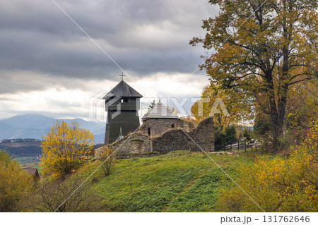 Wooden church in The Liptovska Anna village in northern Slovakia, Europe. Scenic view of a historic church ruin with a wooden tower under a cloudy sky in a rural setting. 131762646