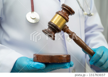 Asian doctor holding court hammer for and crime law justice, forensic medicine. Asian doctor holding court hammer for and crime law justice, forensic medicine. 131763037
