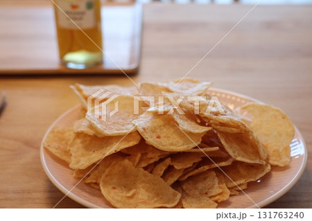 木製テーブルに積み上げられたカリカリポテトチップス 131763240