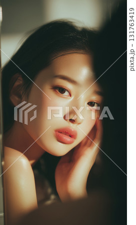 Captivating portrait of a young Korean woman with soft features and elegant makeup illuminated by warm light 131763419