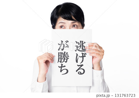 逃げるが勝ちと書かれた紙を持つショートヘアーのシニア女性 131763723