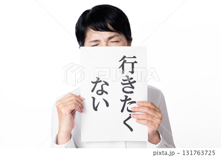 行きたくないと書かれた紙を持ち嫌そうな表情のシニア女性 行きたくないと書かれた紙を持ち嫌そうな表情のシニア女性 131763725