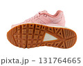 Pair of fashionable pink leather sneakers, isolated on a white background with one sneaker showing its sole. This photo is perfect for showcasing footwear or for use in fashion and lifestyle content. 131764665