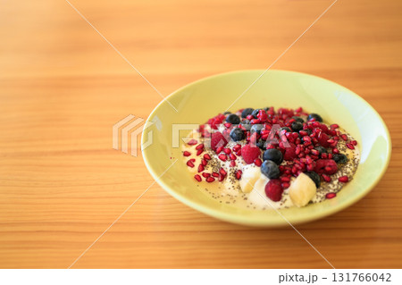 Homemade yoghurt with fresh berries and chia seeds in plate on a wooden table 131766042