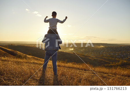 Little child boy walking with father sitting on his shoulders and enjoying nature outdoors. Little child boy walking with father sitting on his shoulders and enjoying nature outdoors. 131766213