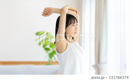 リビングでストレッチをする若い女性 131766374