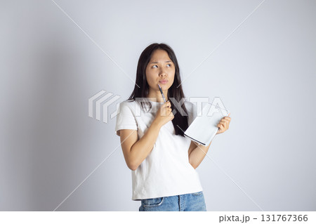 The woman is holding a white tablet and thinking 131767366