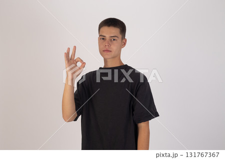 Young boy in black t-shirt making peace sign 131767367