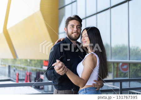A couple is dancing together while holding hands A couple is dancing together while holding hands 131767395