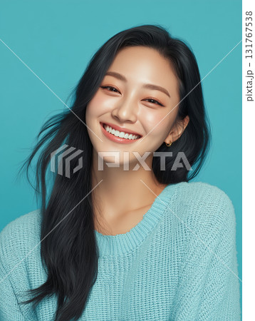 Woman with long dark hair smiling brightly against a light blue background during a cheerful indoor photoshoot 131767538
