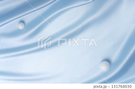 Smooth blue fabric with two white spheres like snowballs. Minimal festive background for Christmas, winter sale or product display. 131768030