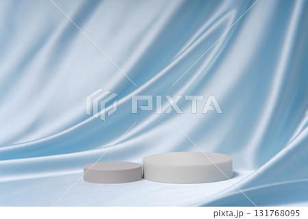 Elegant light blue satin folds with two cylinder podiums and wide copy space. Luxury background for product sets, comparisons and premium advertising. Elegant light blue satin folds with two cylinder podiums and wide copy space. Luxury background for product sets, comparisons and premium advertising. 131768095