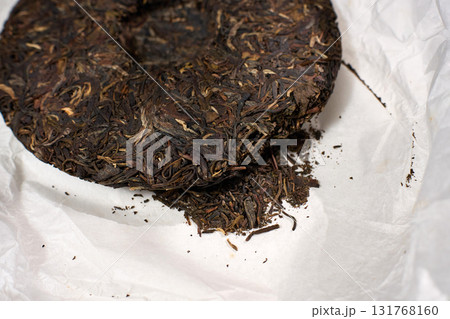 Compressed cake of puer tea showcases its dark leaves and texture. 131768160