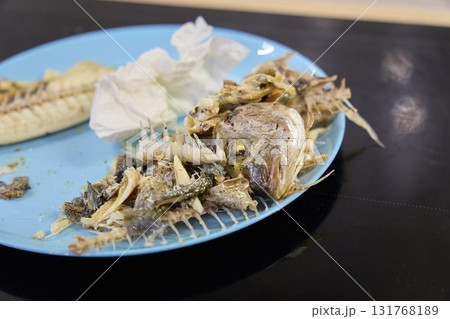 Dorado fish served on a plate with bones and remnants after a meal Dorado fish served on a plate with bones and remnants after a meal 131768189