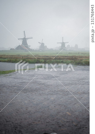 Scenic view of traditional Dutch windmills in Zaandam with changing skies, from calm daylight to approaching rain. Scenic view of traditional Dutch windmills in Zaandam with changing skies, from calm daylight to approaching rain. 131768443