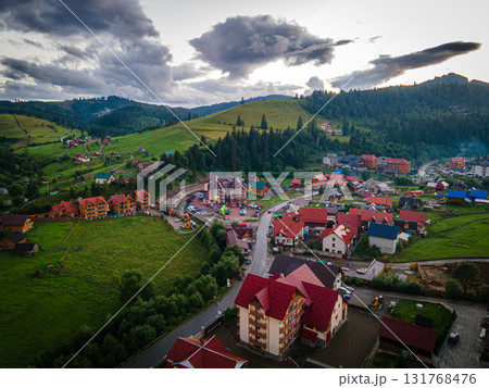 Mountainous countryside scenery at sunset. Dramatic sky above the distant valley. Green fields and trees on the hill. Beautiful nature scenery of carpathians. High quality photo 131768476