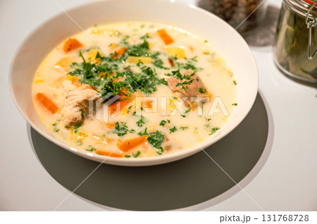Traditional Belgian Waterzooi dish close-up, featuring creamy broth with fish, seafood, potatoes, and vegetables - a classic comfort food from Belgium. 131768728