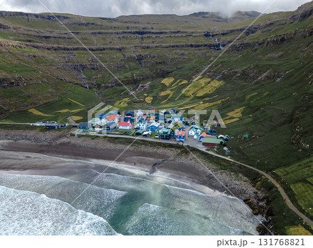 Scenic view of Tjornuvik, a charming village on the north coast of Streymoy, surrounded by dramatic mountains and ocean. 131768821