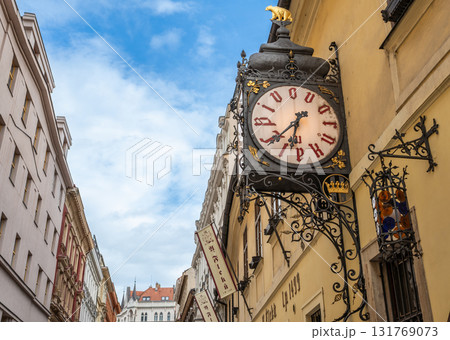 Prague, Czech Republic, August 7, 2023. A shot of the entrance to the U Fleku brewery, the oldest and most famous in the city. The beautiful vintage street clock is prominent. Travel destinations. Prague, Czech Republic, August 7, 2023. A shot of the entrance to the U Fleku brewery, the oldest and most famous in the city. The beautiful vintage street clock is prominent. Travel destinations. 131769073