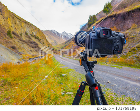Camera on tripod taking photograph in mountainous region Camera on tripod taking photograph in mountainous region 131769198