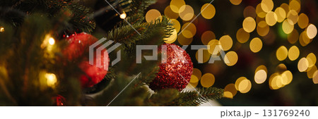 Banner red christmas baubles on fir tree branch with golden bokeh lights Banner red christmas baubles on fir tree branch with golden bokeh lights 131769240