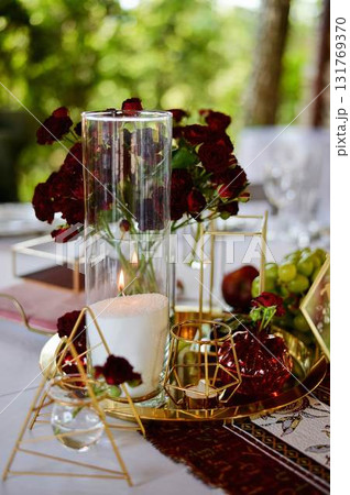 Red decorative vase in the shape of a pomegranate. Wedding table d cor. Gold and white Red decorative vase in the shape of a pomegranate. Wedding table d cor. Gold and white 131769370