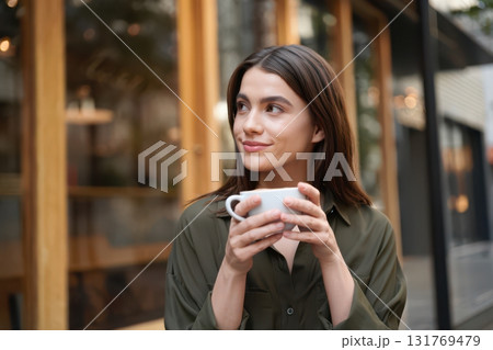 Young woman enjoying coffee moments in outdoor cafe 131769479